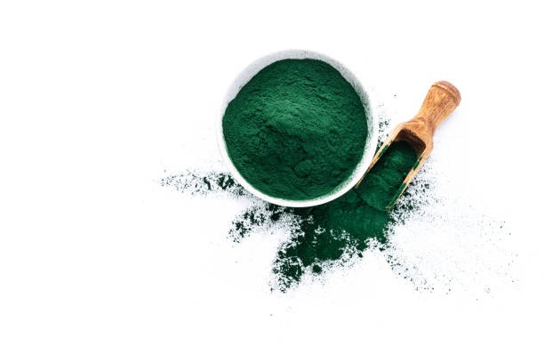 Overhead view of a white bowl filled with Spirulina powder isolated on white background. High resolution 42Mp studio digital capture taken with Sony A7rII and Sony FE 90mm f2.8 macro G OSS lens