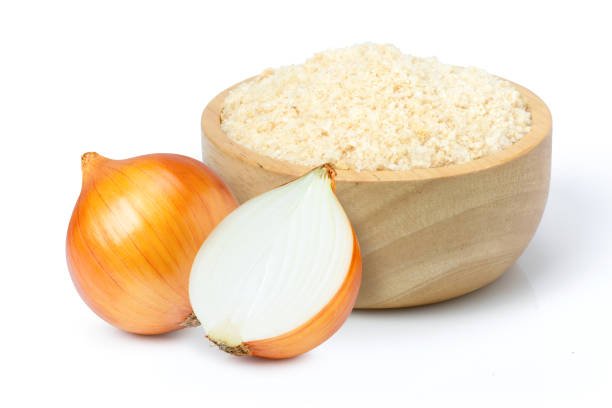 Ground onion or onion powder in wooden bowl and fresh onion with half sliced isolated on white background.
